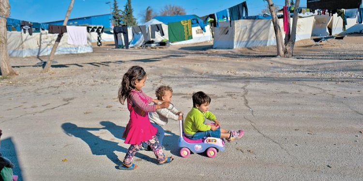 Afghan refugee children play at the refugee camp of Oinofyta about 58 kilometers (36 miles) north of Athens, Monday, Jan. 2, 2017. Over 62,000 refugees and migrants are stranded in Greece after a series of Balkan border closures and an European Union deal with Turkey to stop migrant flows. (AP Photo/Muhammed Muheisen)