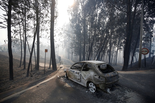 A burned car is seen in the aftermath of a forest fire near Pedrogao Grande, in central Portugal, June 18, 2017. REUTERS/Rafael Marchante TPX IMAGES OF THE DAY