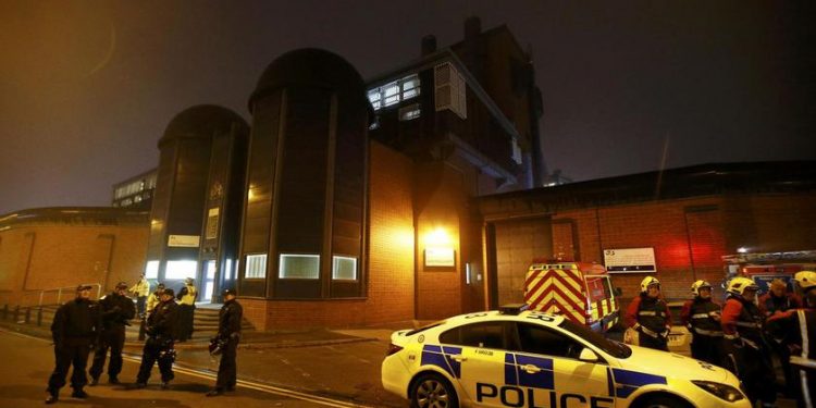 Police officers and firemen stand outside Winson Green prison, run by security firm G4S, after a serious disturbance broke out, in Birmingham