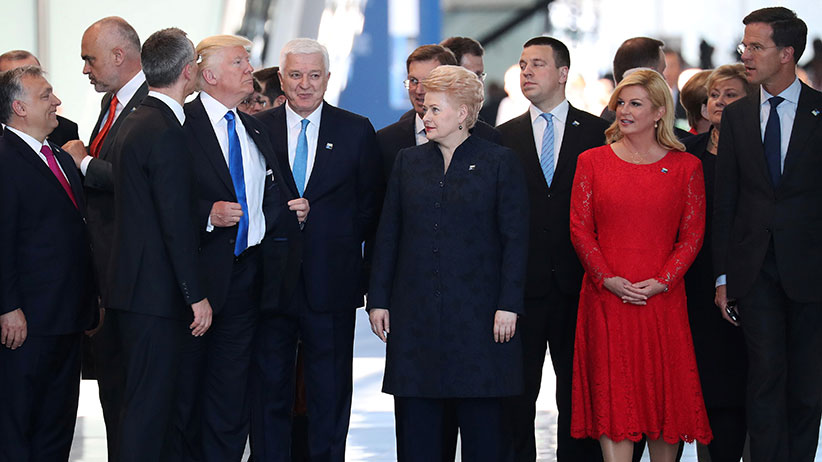 U.S. President Donald Trump adjusts his jacket after pushing past Montenegro Prime Minister Dusko Markovic