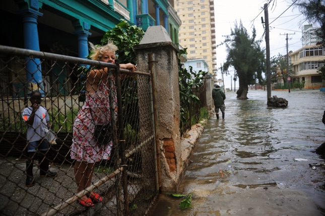 A woman looks at a flooded street during the passage of Hurricane Irma in Havana, on September 9, 2017.  Irma's blast through the Cuban coastline weakened it to a Category Three, but it is still packing winds of 125 miles (200 kilometer) per hour. / AFP PHOTO / YAMIL LAGE