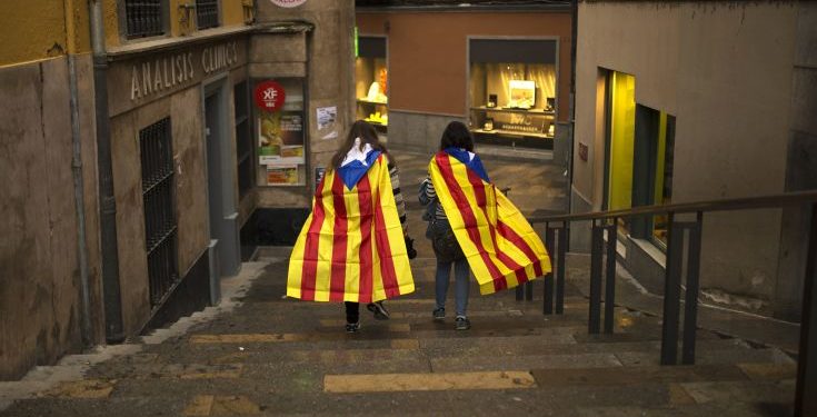 Women with "esteladas," or Catalonia independence flag, walk along the old quarter in Girona, Spain, Monday, Oct. 2, 2017. Catalonia's government will hold a closed-door Cabinet meeting Monday to discuss the next steps in its plan to declare independence from Spain following a disputed referendum marred by violence. Regional officials say the vote, which Spain insists was illegal and invalid, shows that a majority favor secession. (AP Photo/Francisco Seco)