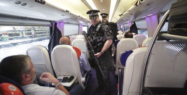 Armed British Transport Police Specialist Operations officers on board a  train to Birmingham New Street at Euston station in London as armed police officers are patrolling on board trains nationwide for the first time Thursday May 25, 2017. British Transport Police announced the measure in a bid to "disrupt and deter criminal activity" on the rail network after the UK terror threat level rose to critical in the wake of the Manchester attack. (Yui Mok/PA via AP)