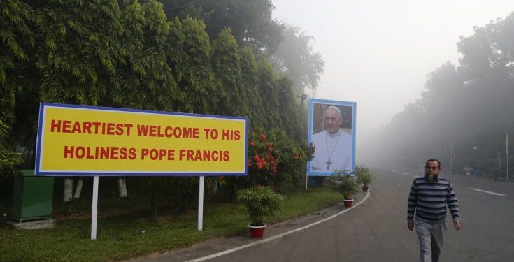 A Bangladeshi man walks past a welcome message and a portrait of Pope Francis displayed along a route the Pope is expected to take during his visit, in Dhaka, Bangladesh, Thursday, Nov. 30, 2017. Pope Francis is expected to arrive in Bangladesh Thursday on the second leg of his weeklong South Asia tour. (AP Photo/Aijaz Rahi)