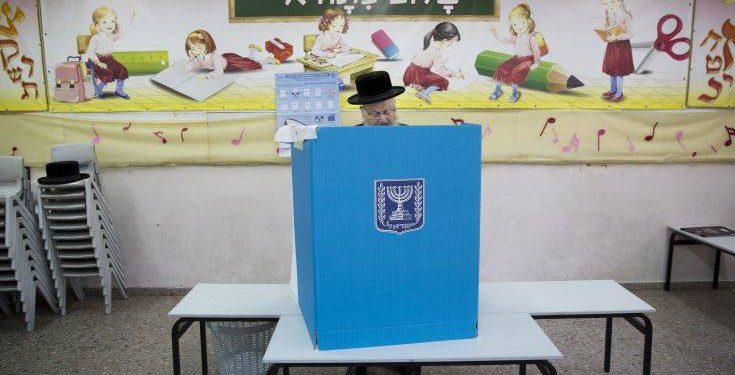 An ultra-Orthodox Jewish man votes for Israel's parliamentary election at a polling station in Bnei Brak, Israel, Tuesday, April 9, 2019. (AP Photo/Oded Balilty)