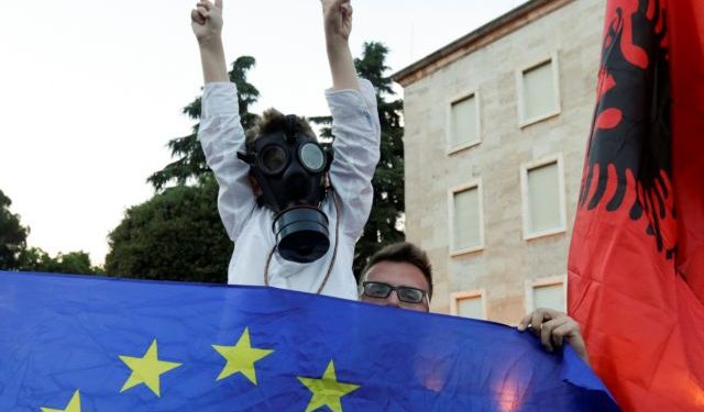 A child wearing a gask mask attends an anti-government protest, calling on Prime Minister Edi Rama to step down, in Tirana