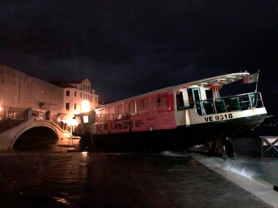 This image made available by the Municipality of Venice shows a ferry stranded on the docks in Venice, Italy, after an exceptional high tide, reaching 1.87 meters above sea level on Tuesday, Nov. 12, 2019. It's the second highest tide peak in Venice in recorded history. On Nov. 4, 1966 waters reached 1.94 meters. (Venice Municipality via AP)