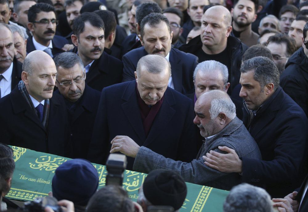 Turkey's President Recep Tayyip Erdogan, centre, comforts relatives of a victim after an earthquake hit Elazig, eastern Turkey, Friday, during the funeral procession for Salih Civelek and Aysegul Civelek, Saturday, Jan. 25, 2020. Rescuers continued searching for people buried under the rubble of collapsed buildings while emergency workers and security forces distributed tents, beds and blankets in the affected areas. Mosques, schools, sports halls and student dormitories were opened for hundreds who left their homes after the quake. (Presidential Press Service via AP, Pool)