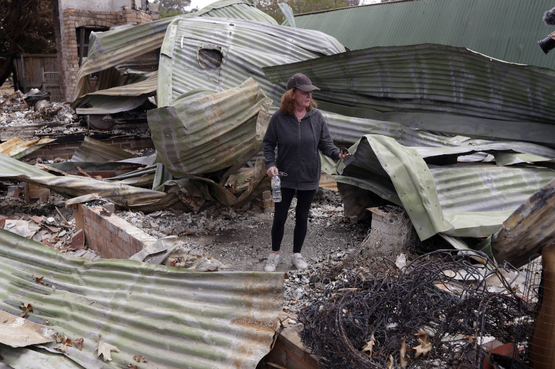 Rosemary Doyle stands in her destroyed home at Balmoral, Australia, Tuesday, Jan. 7, 2020. Doyle's home is among 2,000 in Australia burned down as the wildfires continue. (AP Photo/Rick Rycroft)