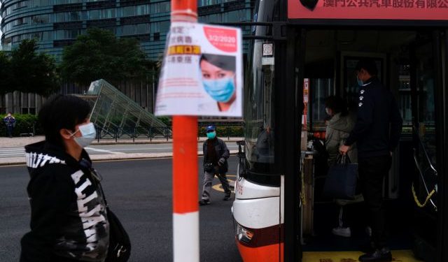 Passengers wear mask at a bus stop, following the coronavirus outbreak in Macau