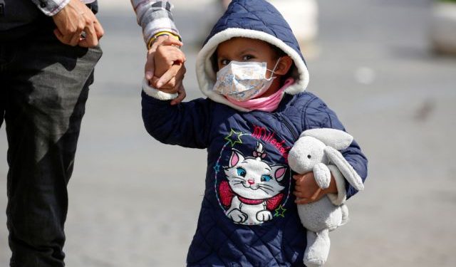 A child wearing a protective face mask walks near the Colosseum, after a decree orders for the whole of Italy to be on lockdown in an unprecedented clampdown aimed at beating the coronavirus, in Rome