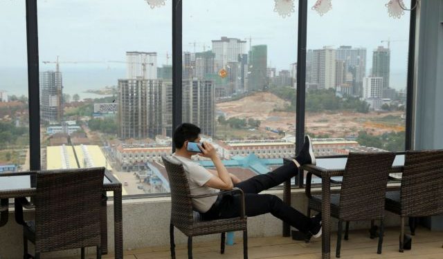 A man speaks on his phone on the rooftop of Chinese businessman Kang Quiang's casino Dong Yuan, in Sihanoukville, Cambodia, February 28, 2020. REUTERS/Jorge Silva     SEARCH "COVID-19 CAMBODIA CASINOS" FOR THIS STORY. SEARCH "WIDER IMAGE" FOR ALL STORIES.