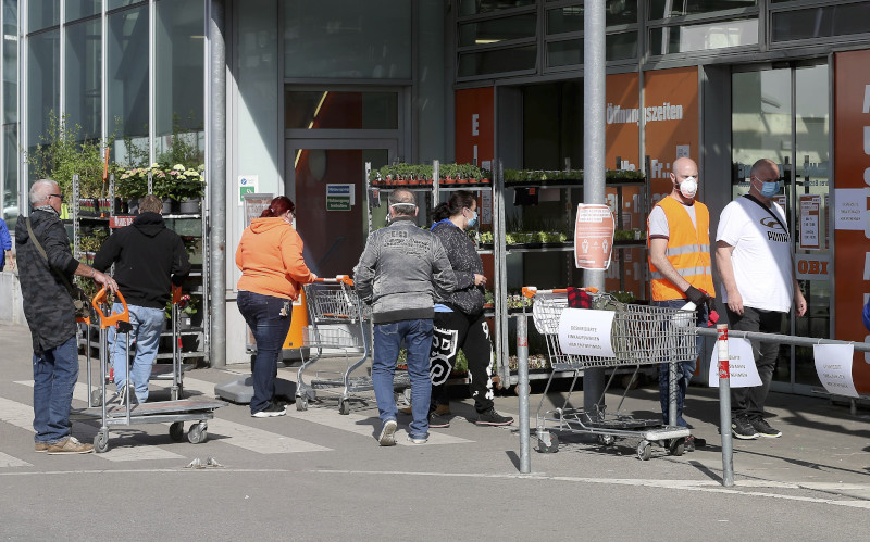 People with protective masks queue up to go in a hardware store in Vienna, Austria, Tuesday, April 14, 2020. Smaller Austrian shops may reopen with special protective measures from Tuesday on. The Austrian government has moved to restrict freedom of movement for people, in an effort to slow the onset of the COVID-19 coronavirus. The new coronavirus causes mild or moderate symptoms for most people, but for some, especially older adults and people with existing health problems, it can cause more severe illness or death. (AP Photo/Ronald Zak)