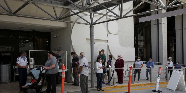 People wait for health assessment check-in before entering Jackson Memorial Hospital, as Miami-Dade County eases some of the lockdown measures put in place during the coronavirus disease (COVID-19) outbreak, in Miami, Florida, U.S., June 18, 2020. REUTERS/Marco Bello