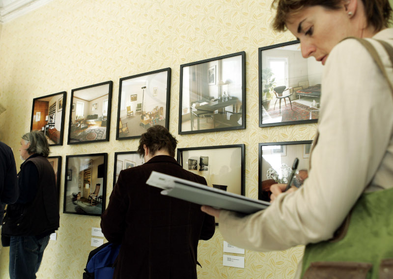 Besucher betrachten am Donnerstag, 4. Mai 2006 waehrend einer Pressefuehrung durch die Ausstellung "Die Couch" im Sigmund Freud Museum in Wien Fotos von Praxen von verschiedenen Analytikern. (AP Photo/Lilli Strauss)