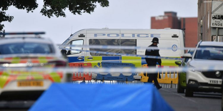 A police officer and vehicles are seen at a cordon in Irving Street in Birmingham after a number of people were stabbed in the city centre, Sunday, Sept. 6, 2020. British police say that multiple people have been injured in a series of stabbings in a busy nightlife area of the central England city of Birmingham.(Jacob King/PA via AP)