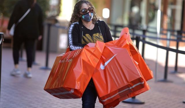 FILE PHOTO: A woman carries Nike shopping bags at the Citadel Outlet mall, as the global outbreak of the coronavirus disease (COVID-19) continues, in Commerce