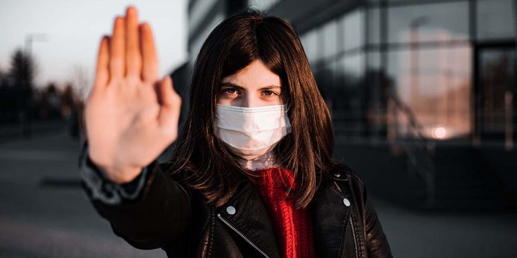 Young girl shows hand sign stop no to coronavirus epidemic pandemia originated at China. Covid-19 virus, nCov2019. Girl is against using public transport and stay home during quarantine