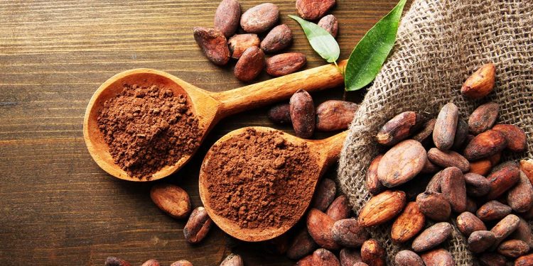19174697 - cocoa powder in spoons and cocoa beans on wooden background