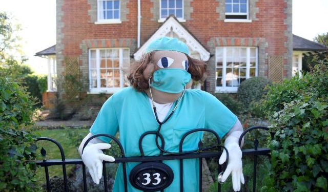 A figure representing a key worker is seen in a front garden as various scarecrows lighten the daily lockdown walk, as the number of the coronavirus disease cases (COVID-19) grows around the world, in the village of Capel in southern Britain, April 26, 2020. Picture taken April 26, 2020. REUTERS/Toby Melville