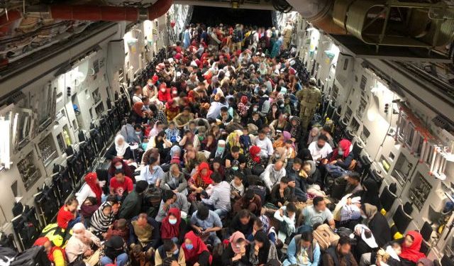 Evacuees sit in an RCAF C-177 Globemaster III transport plane en route to Canada