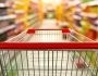 Supermarket aisle interior blur background with empty red shopping cart
