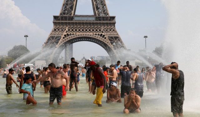 FILE PHOTO: People cool off in the Trocadero fountains across from the Eiffel Tower in Paris