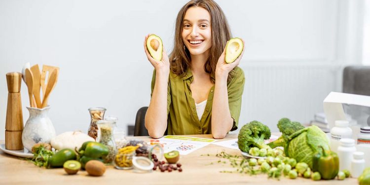 Young woman with fresh vegan food ingredients