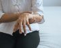 Elderly woman suffering with parkinson's disease symptoms on hand