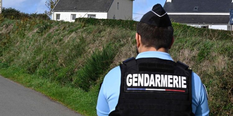 A french gendarme stands guard on a road next to a house where four people have been found dead, in Carantec, western France on october 30, 2022. - A man, a woman and two young girls from the same family were found dead on October 30, 2022 in a house in Carantec, near Morlaix, western France. (Photo by DAMIEN MEYER / AFP)