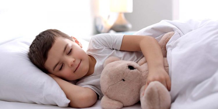 Little boy sleeping with teddy bear at home. Bedtime