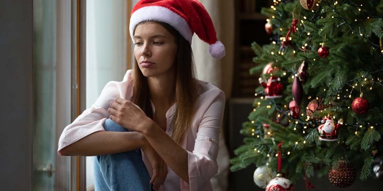Frustrated,Xmas,Young,Woman,Getting,Bored,At,Christmas,Tree,,Sitting