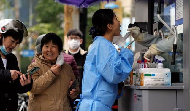 A woman gets swabbed to be tested for the coronavirus disease (COVID-19) at a nucleic acid testing site in Shanghai, China December 7, 2022. REUTERS/Aly Song