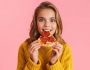 Excited,Beautiful,Blonde,Girl,Eating,Pizza,At,Camera,Isolated,Over