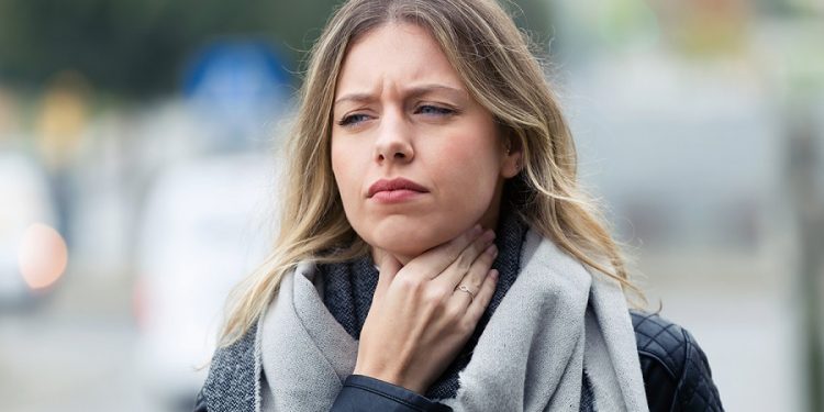 Illness young woman with terrible throat pain walking to the str