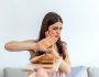 Cropped shot of a young woman on a gluten free diet is saying no thanks to white bread. Woman refusing to eat white bread. Gluten intolerance concept. Health care and medicine concept. Copy space.