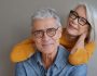 Portrait of relaxed fun senior couple wearing glasses on background