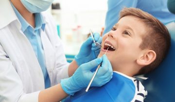 Dentist,Examining,Little,Boy's,Teeth,In,Clinic