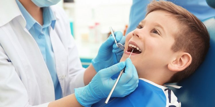 Dentist,Examining,Little,Boy's,Teeth,In,Clinic