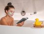 Bath at home woman relaxing taking a warm bath reading book cozy enjoying free time putting facial clay mask pampering weekend. Bubble bath spa time.