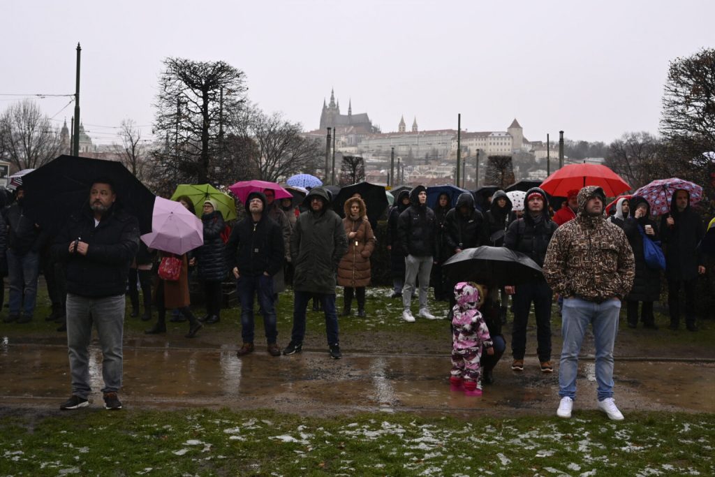 Mourners observe a minute of silence for the victims of mass shooting in front of the building of Philosophical Faculty of Charles University in downtown Prague, Czech Republic, Saturday, Dec. 23, 2023. A lone gunman opened fire at a university on Thursday, killing more than a dozen people and injuring scores of people. (AP Photo/Denes Erdos)