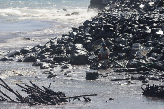 A worker cleans the Lambeau Village river mouth, a week after an oil spill was first spotted, in Tobago Island, Trinidad and Tobago, February 14, 2024. REUTERS/Clement George Williams NO RESALES. NO ARCHIVES