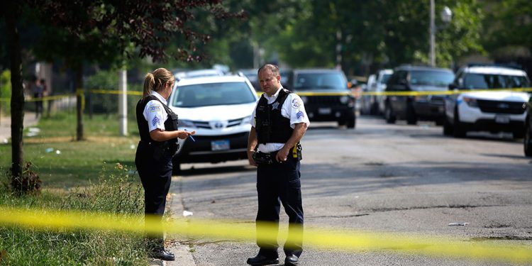 epa06947120 Chicago Police officers investigate a crime scene where a man was shot in the arm in Chicago, Illinois, USA, 12 August 2018. According to statistics Chicago has more victims shootings and stabbings than both New York City and Los Angeles together. Both cities are larger than Chicago.  EPA/JOSHUA LOTT