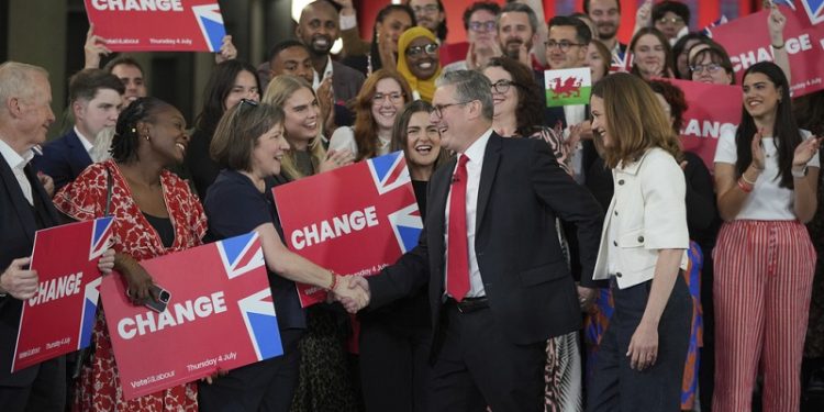 Labour Party leader Keir Starmer shakes hands with his supporters at the Tate Modern in London, Friday, July 5, 2024. Labour Party Starmer says voters "have spoken and they are ready for change" as an exit poll points to landslide win, and is expected to be the next British Prime Minister. (AP Photo/Kin Cheung)