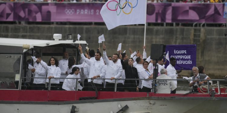 The Refugees Olympic Team goes down the Seine River in Paris, France, during the opening ceremony of the 2024 Summer Olympics, Friday, July 26, 2024. (AP Photo/Kin Cheung)
