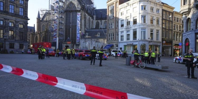 Police officers stand behind a cordoned off area after a stabbing near Dam Square in central Amsterdam, Thursday, March 27, 2025. (AP Photo/Peter Dejong)