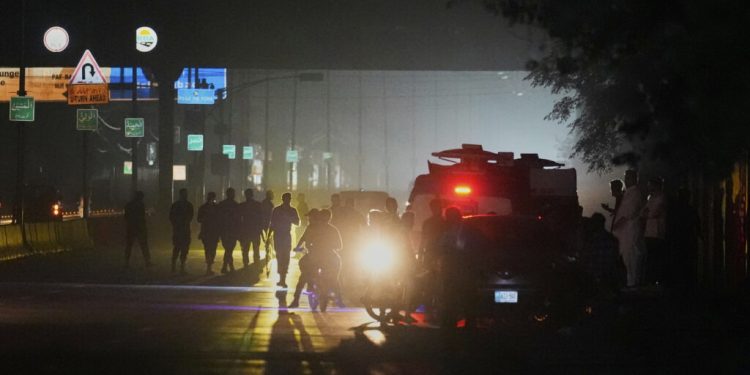Pakistani police officers remove vehicles and people from the main entry of Nur Khan airbase following an Indian missile strike in Rawalpindi, Pakistan, Saturday, May 10, 2025. (AP Photo/Anjum Naveed)
